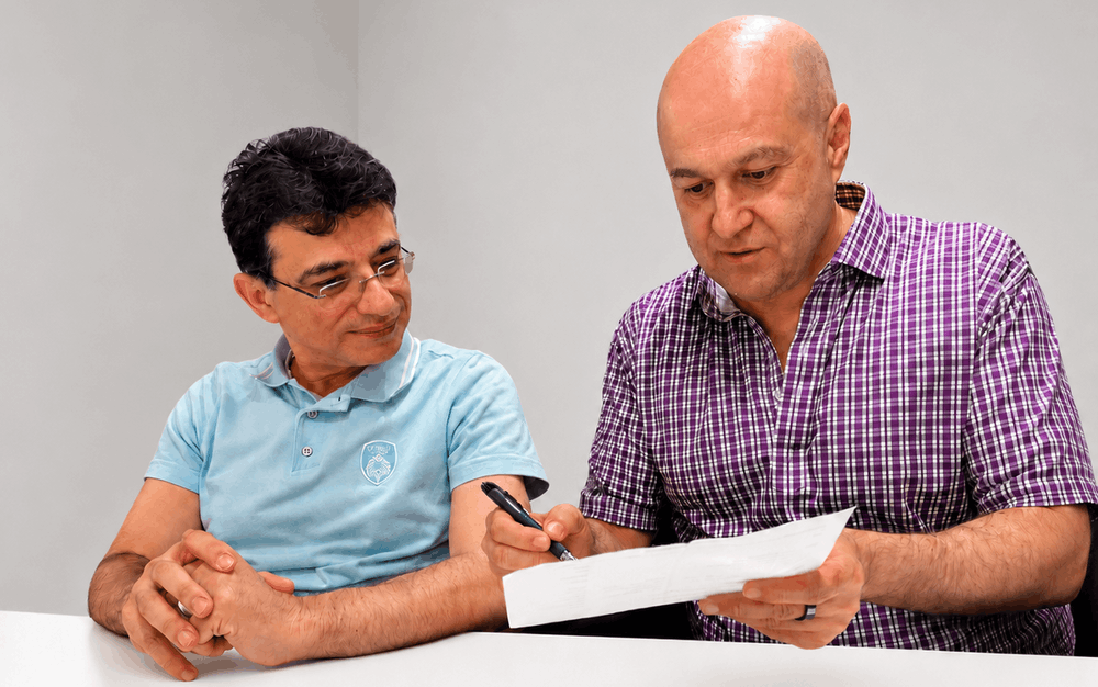 Dr. Slava Fuzayloff, DO reviewing a traveler's itinerary and vaccination records at Travel Clinic NYC in Midtown Manhattan